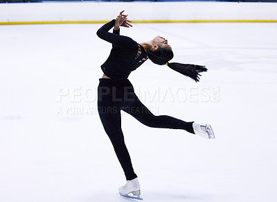 Buy stock photo Shot of a young woman figure skating at a sports arena