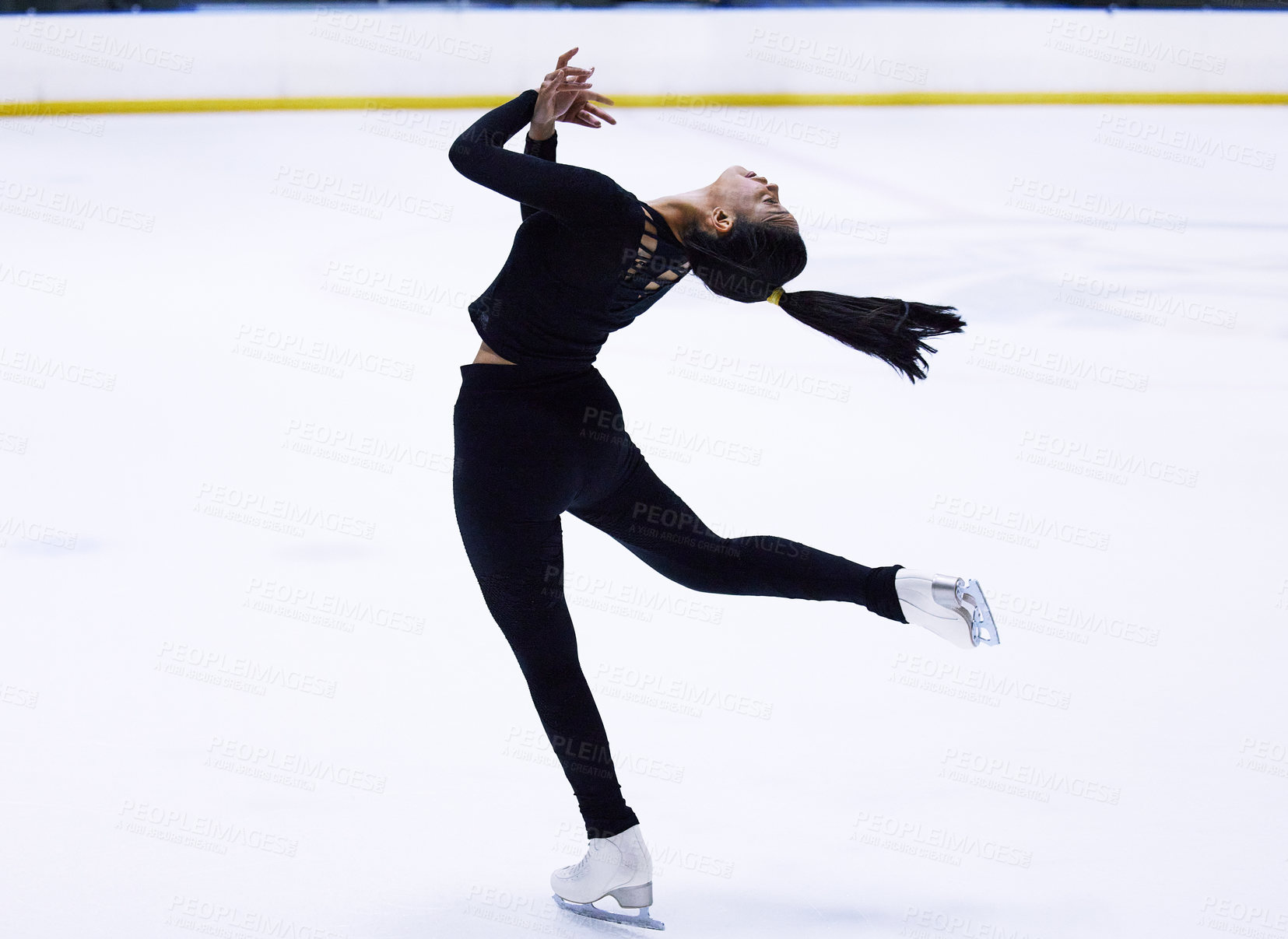 Buy stock photo Shot of a young woman figure skating at a sports arena