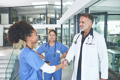 Buy stock photo Cropped shot of an attractive young nurse standing and shaking a doctor's hand in the clinic