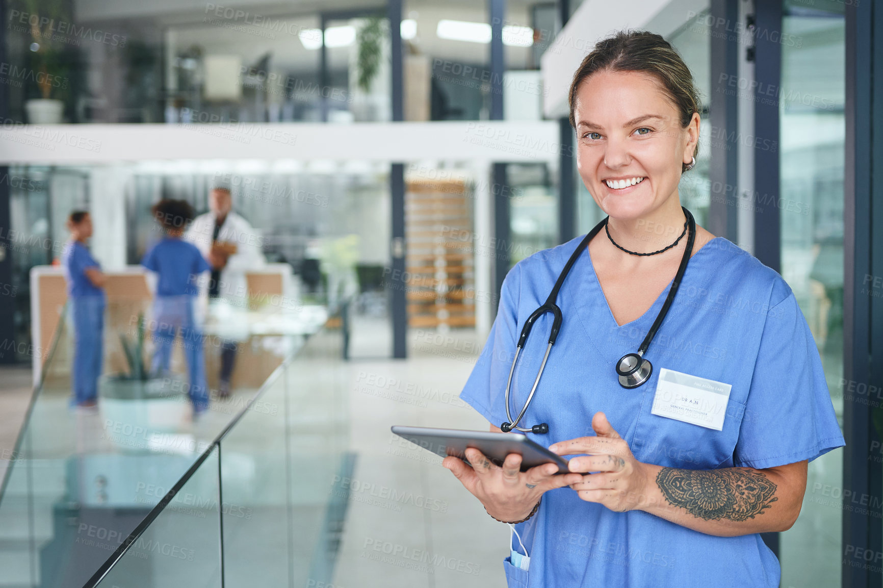 Buy stock photo Cropped portrait of an attractive young nurse standing and using a digital tablet in the clinic