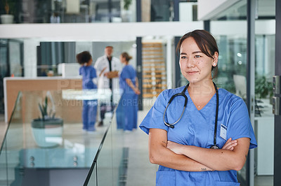 Buy stock photo Cropped shot of an attractive young nurse standing in the clinic during the day with her arms folded