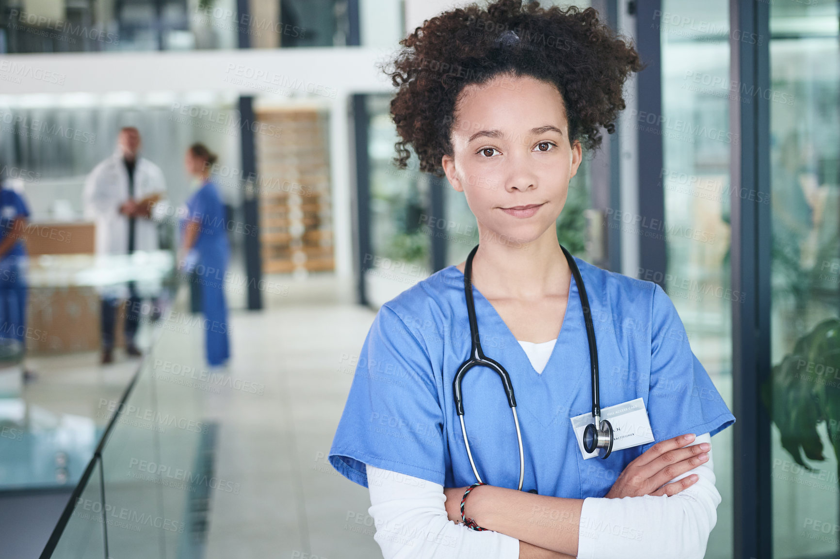 Buy stock photo Cropped portrait of an attractive young nurse standing in the clinic during the day with her arms folded