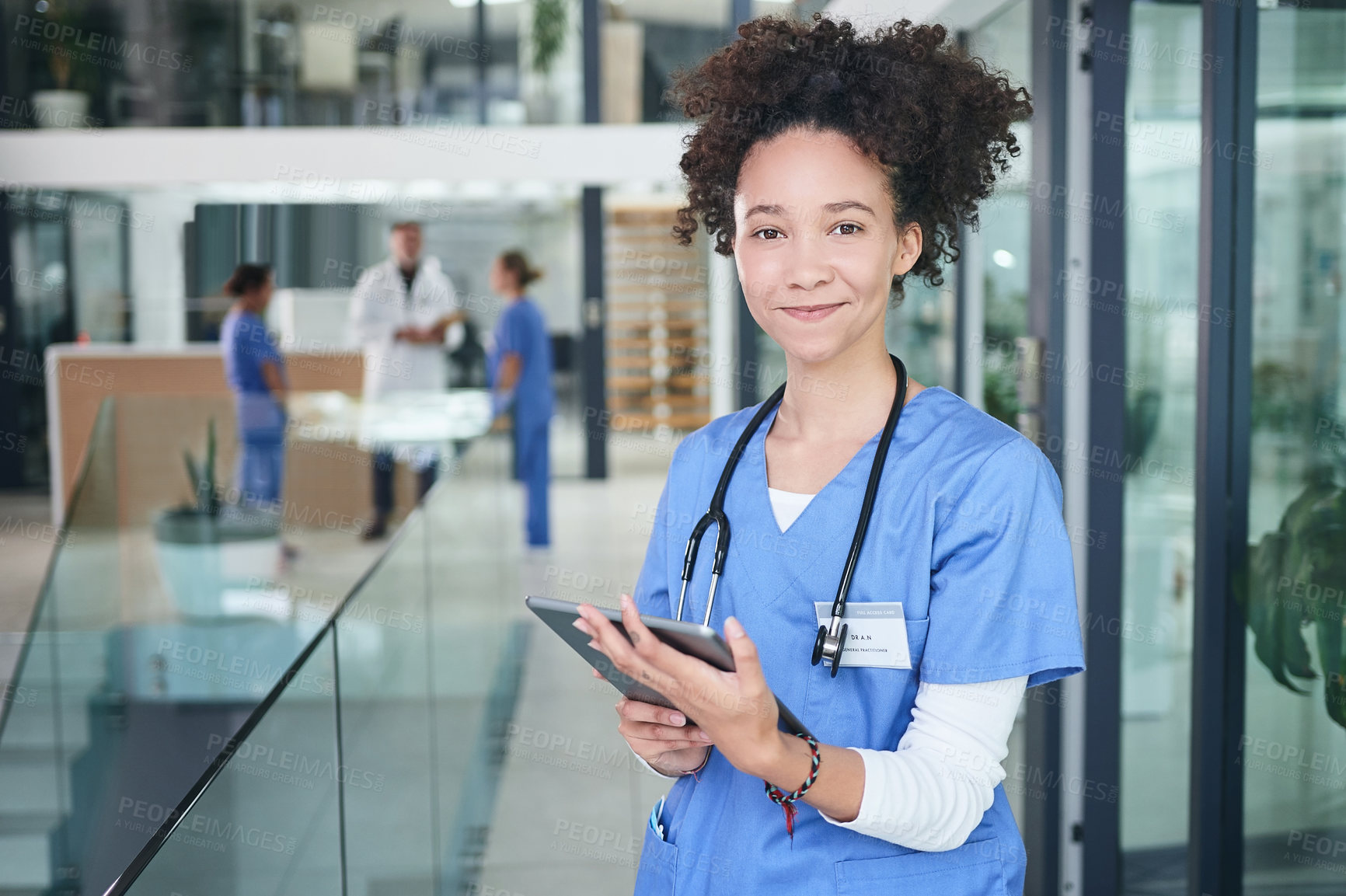 Buy stock photo Cropped portrait of an attractive young nurse standing and using a digital tablet in the clinic