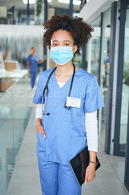 Buy stock photo Cropped portrait of an attractive young nurse wearing a face mask and standing in the clinic