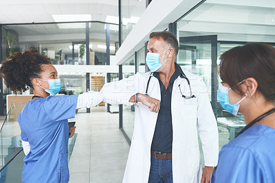 Buy stock photo Cropped shot of a handsome mature doctor standing and elbow bumping his nurse as a greeting in the clinic