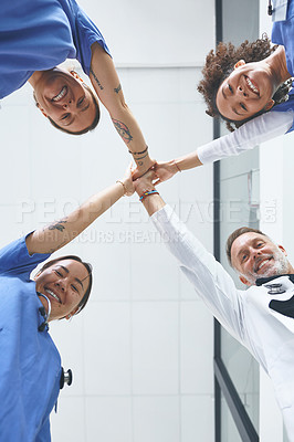 Buy stock photo Low angle portrait of a diverse group of healthcare professionals standing and giving each other a high five