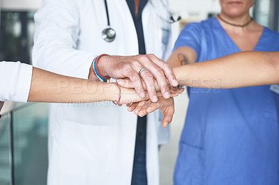 Buy stock photo Cropped shot of an unrecognizable group of healthcare professionals standing huddled together with their hands piled in the middle