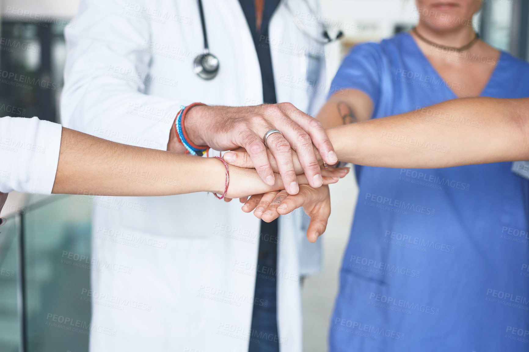 Buy stock photo Cropped shot of an unrecognizable group of healthcare professionals standing huddled together with their hands piled in the middle