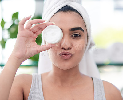 Buy stock photo Shot of young woman posing with facial moisturiser