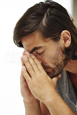 Buy stock photo Shot of a young man looking down in distress