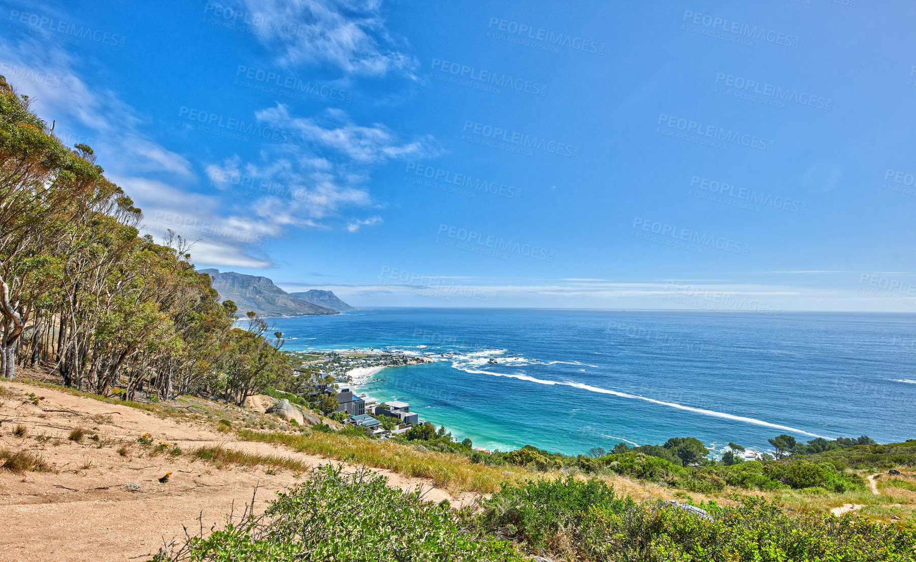 Buy stock photo Panoramic landscape view of the ocean from a mountain trail on Table Mountain in Cape Town, South Africa. Beautiful scenic view of the sea against a clear blue sky from a green hiking path in summer