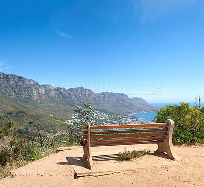 Buy stock photo Bench with a beautiful view of Table Mountain and sea against a clear blue sky background with copy space. Relaxing spot for a peaceful break to enjoy the scenic landscape after a hike up a cliff