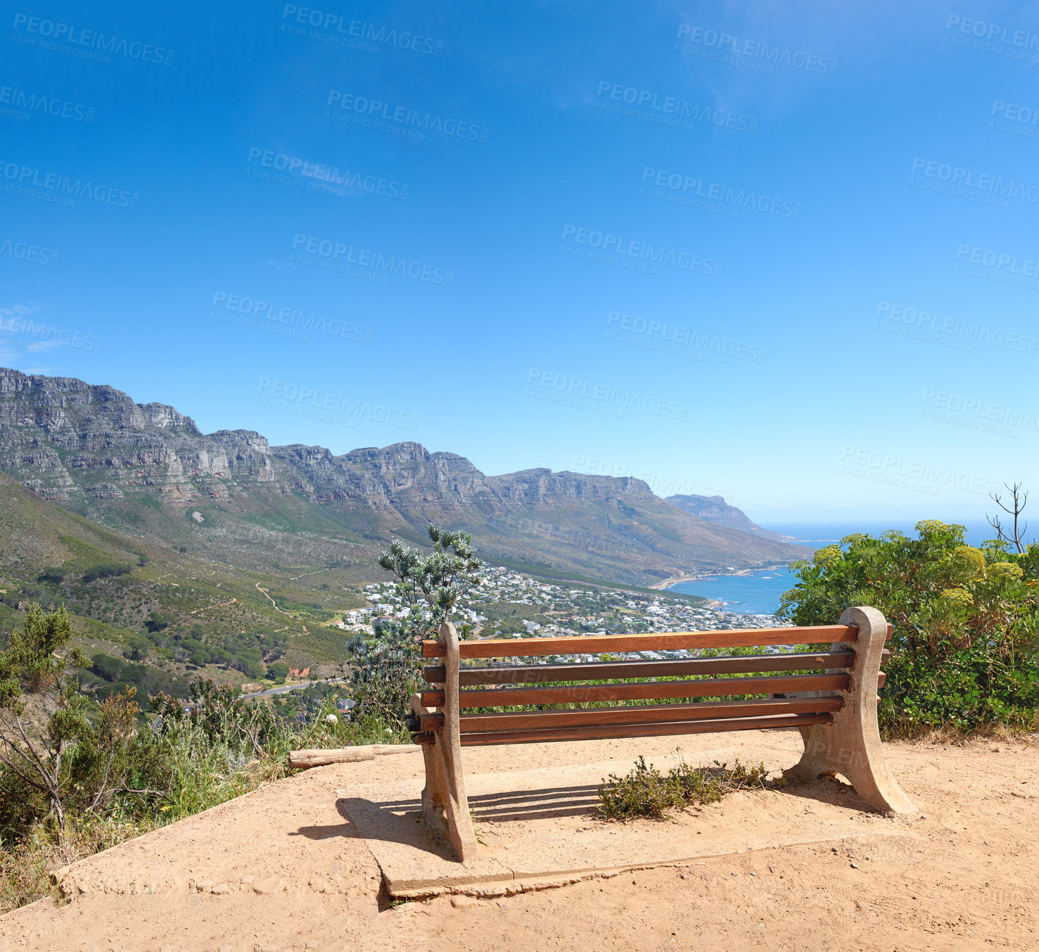 Buy stock photo Bench with a beautiful view of Table Mountain and sea against a clear blue sky background with copy space. Relaxing spot for a peaceful break to enjoy the scenic landscape after a hike up a cliff