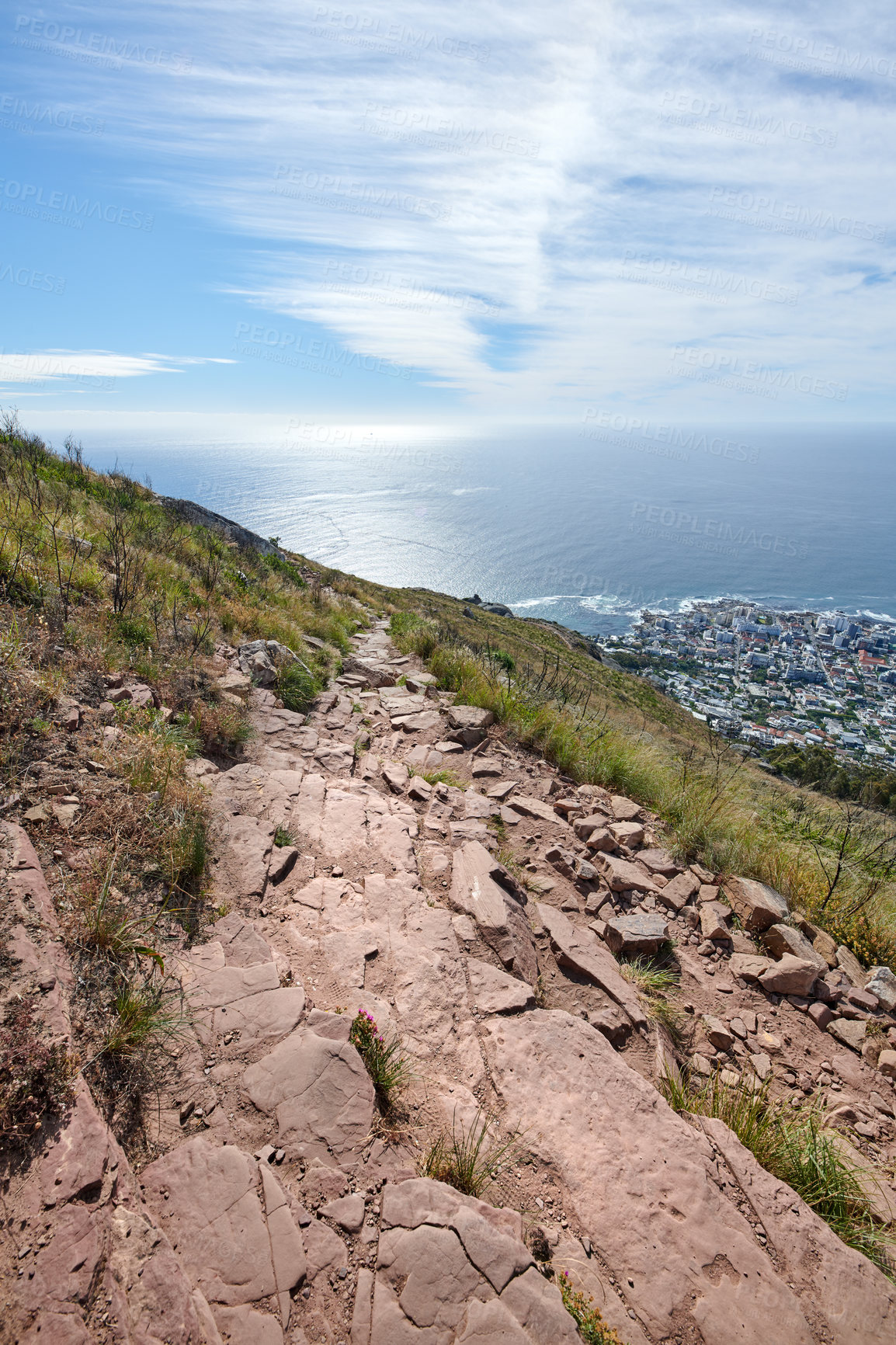 Buy stock photo Mountain, path and nature with ocean, city and blue sky with buildings outdoor for tourism. Sea view, trail and town for travel on holiday with grass, vacation and landscape on coastal hiking route