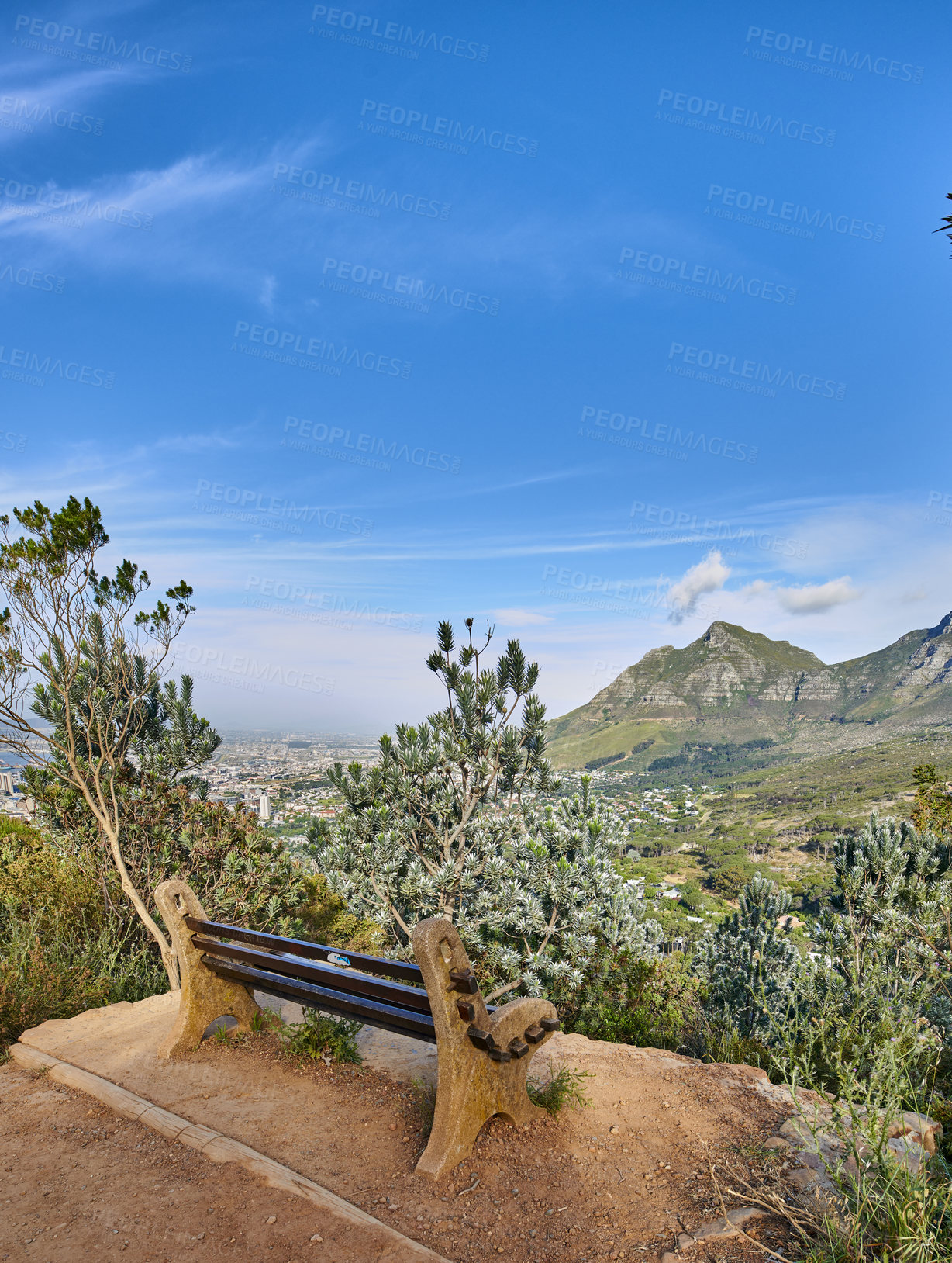 Buy stock photo Bench with a beautiful view of Table Mountain and sea against a clear blue sky background with copy space. Relaxing spot for a peaceful break to enjoy the scenic landscape after a hike up a cliff