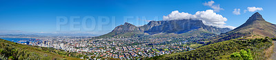 Buy stock photo Panoramic scene of Cape Town, South Africa. Table Mountain, Lion's Head and Signal Hill against a blue sky background, overlooking the city. Aerial view of the urban and natural environments