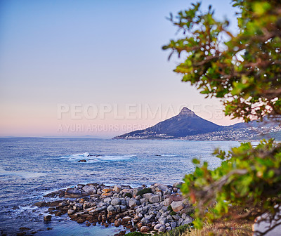 Buy stock photo Stunning ocean coast during sunset with Lions Head mountain in the background. Beautiful sea water on clear evening sky with copy space. Nature landscape or seascape with gentle waves by the shore