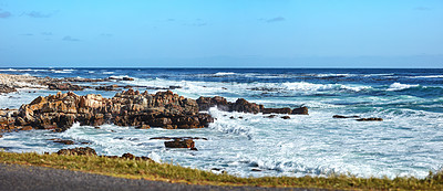 Buy stock photo Stunning blue ocean coast with a clear sky background and copy space. Beautiful sea water splashing against rocky shore under bright summer sky. Open and empty nature landscape or seascape with waves