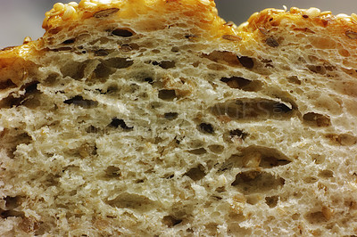 Buy stock photo Closeup detail of a slice of wholewheat bread freshly baked at a bakery to serve breakfast. A cut healthy and tasty bun ready to be served for lunch at a restaurant. A fresh roll sliced for dinner