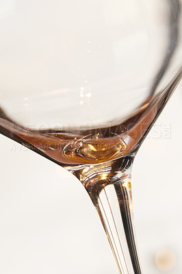 Buy stock photo Closeup of the last sip of white wine against a light background with copyspace. Zoom in on an alcohol beverage being enjoyed in celebration. Macro view of style, shape and design of a wine glass 