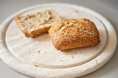 Buy stock photo Sliced seeded wholemeal bread. Fresh brown homemade slices or roll on a wooden cutting board served as a wholesome lunch, breakfast snack meal. Healthy and organic whole wheat or grain loaf