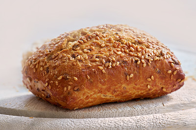 Buy stock photo Closeup of freshly baked bread on a kitchen counter with copy space. Homemade wheat loaf ready to be sliced and served as a meal. Macro details of a seeded bun made fresh in a bakery 