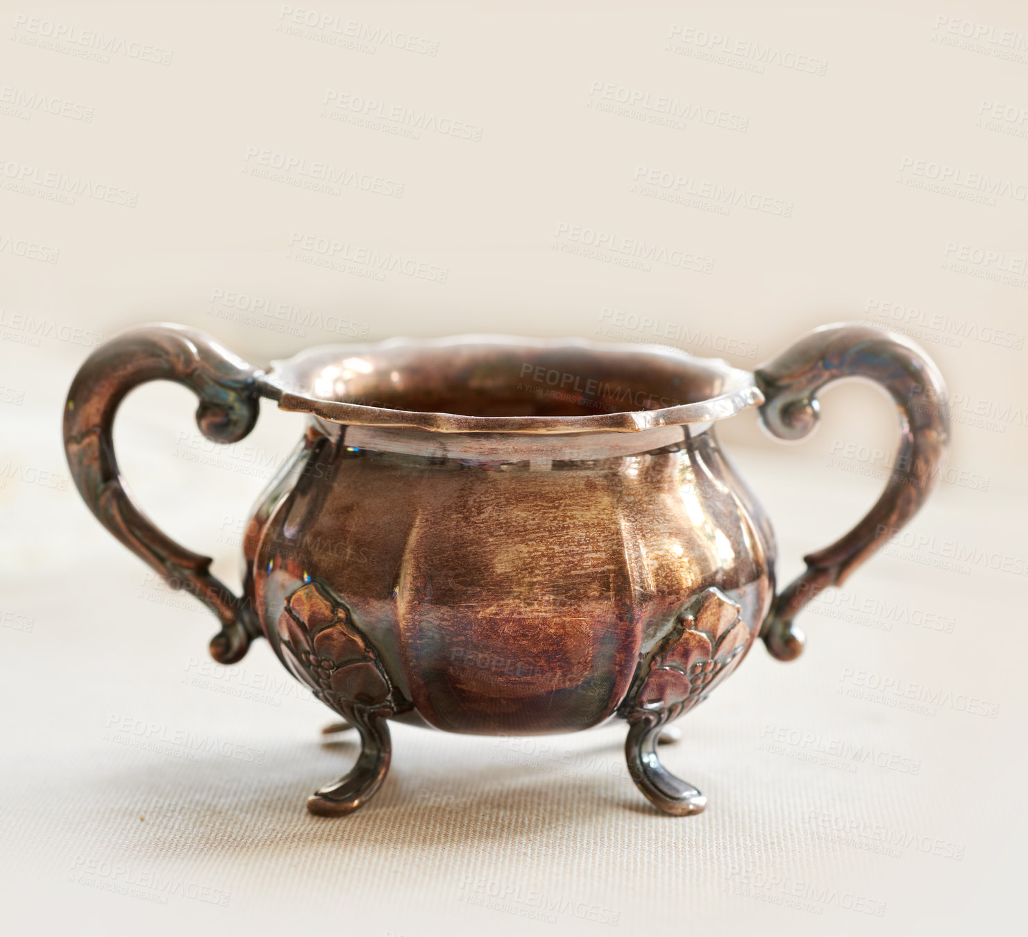 Buy stock photo Metallic antique ornamental pot on a table isolated in studio against a grey background. Old bronze sauce dish. For serving and culinary needs. The perfect pairing for making, cooking and serving food