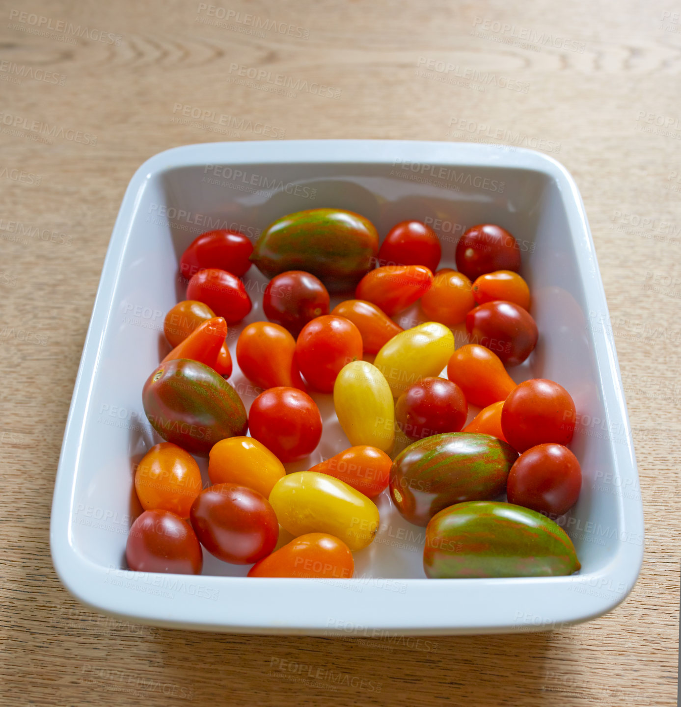 Buy stock photo Closeup of cherry tomatoes ready to cook in a kitchen from Juicy red, yellow and green tomato in a bowl at a restaurant. A superfood that will be added to a healthy, nutritious meal for health