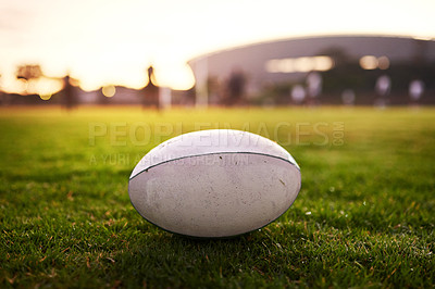 Buy stock photo Cropped shot of a rugby ball on an empty rugby field during the early hours of the morning