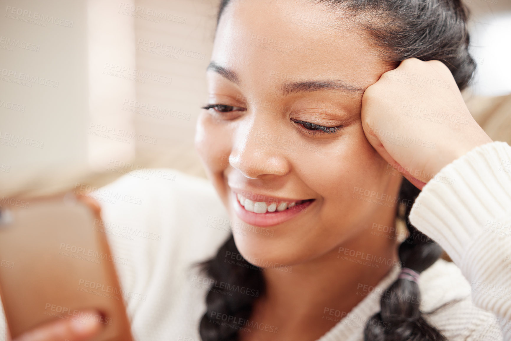 Buy stock photo Shot of a young woman using a smartphone on the sofa at home