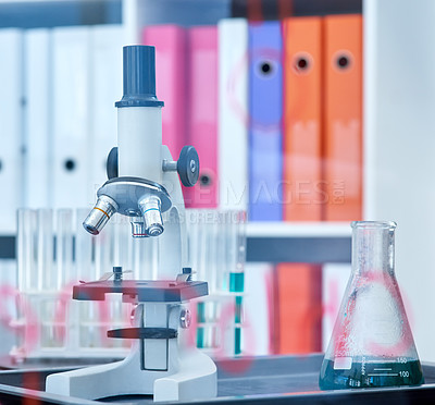 Buy stock photo Closeup shot of a microscope and beaker in a lab