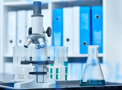 Buy stock photo Closeup shot of a microscope and beaker in a lab