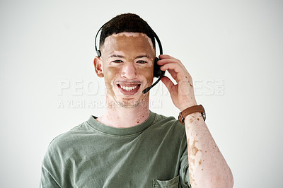 Buy stock photo Studio portrait of a young man with vitiligo wearing a headset against a white background