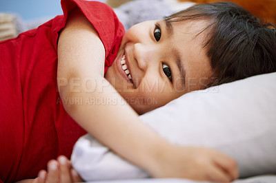 Buy stock photo Smile, cute and boy child on bed playing and having fun at home with positive, good and happy attitude. Laughing, funny and sweet Asian kid relaxing on pillow for nap in bedroom at modern house.