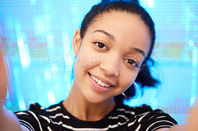 Buy stock photo Portrait of a happy young woman taking selfies against a neon sequinned background