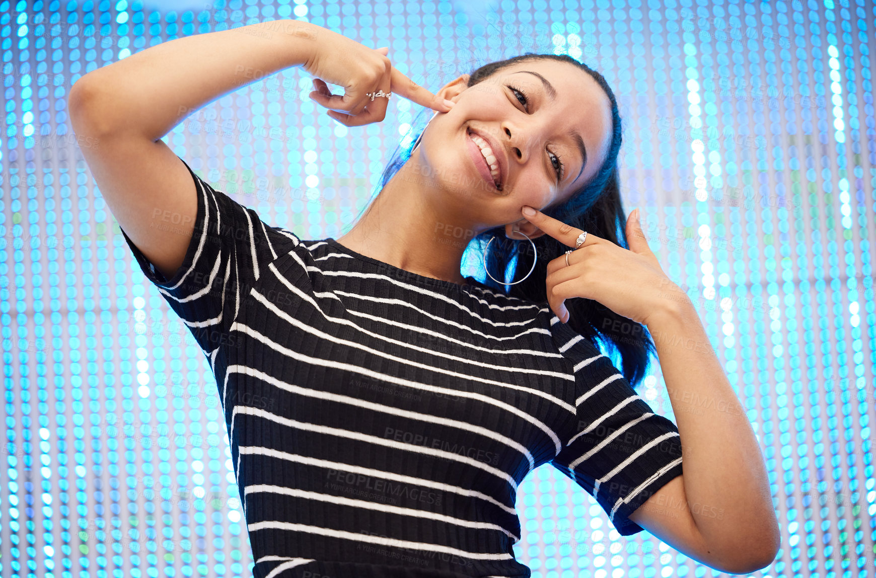 Buy stock photo Portrait of a happy young woman against a neon sequinned background