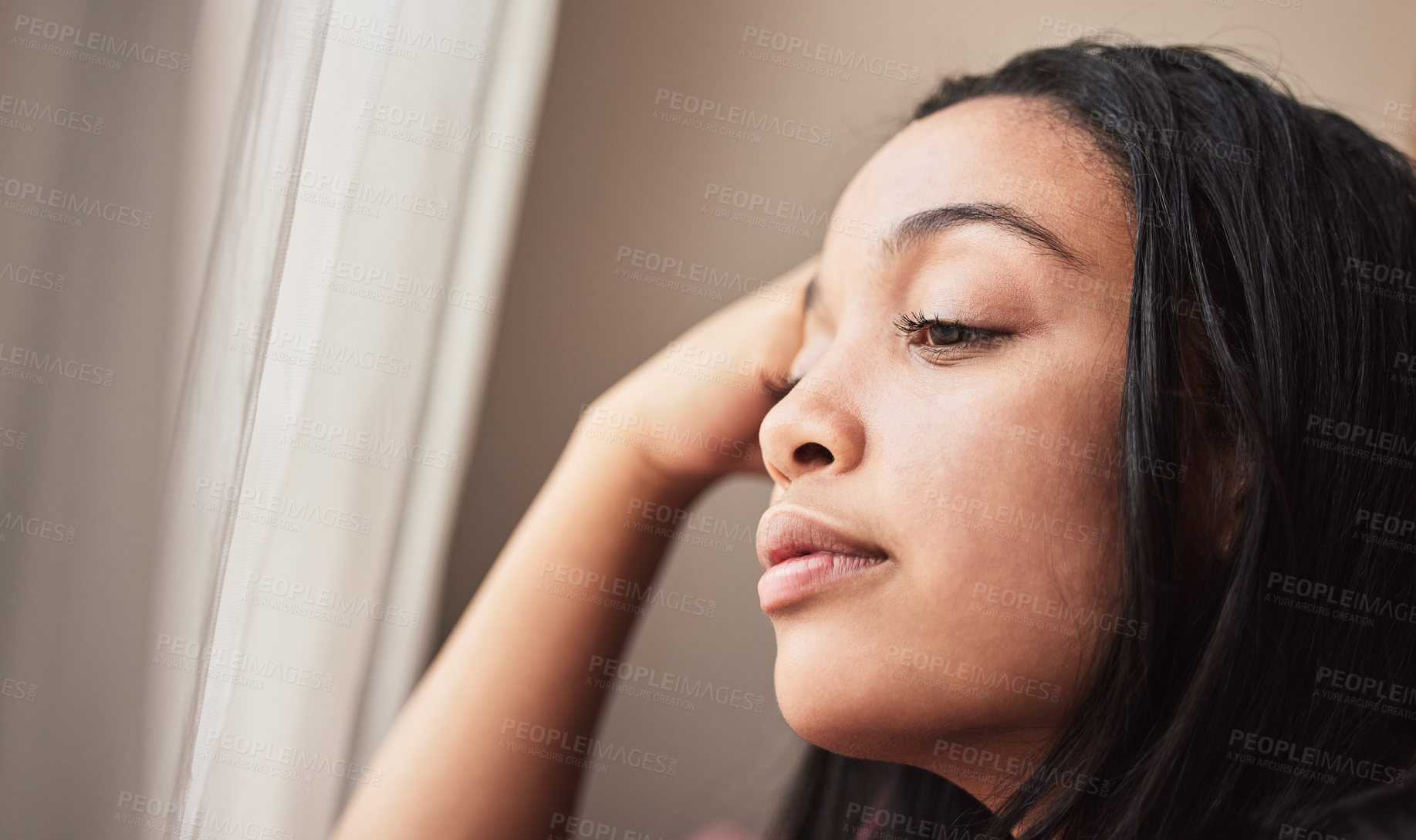 Buy stock photo Shot of young woman looking thoughtful at home