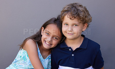 Buy stock photo Shot of a young boy and girl sitting together against a grey background