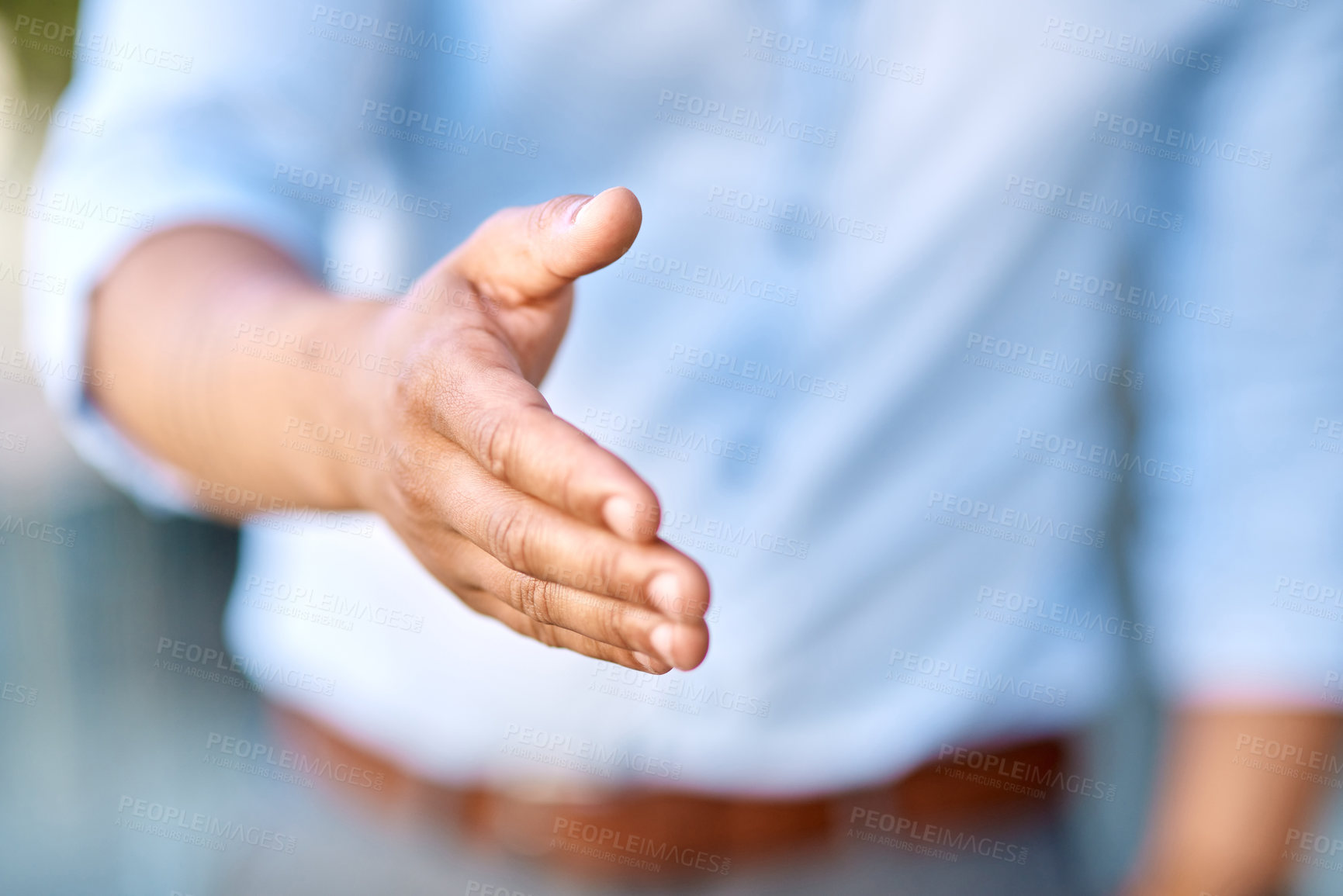 Buy stock photo Cropped shot of an unrecognizable businessman standing with his hand extended for a handshake during the day