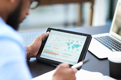 Buy stock photo Cropped shot of an unrecognizable businessman sitting alone in his office and using a digital tablet