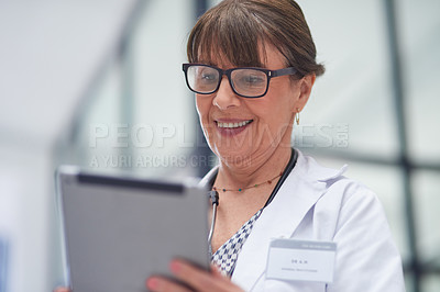 Buy stock photo Shot of a mature female doctor using a tablet