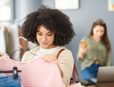 Buy stock photo Cropped shot of a young woman shopping for clothes in a store