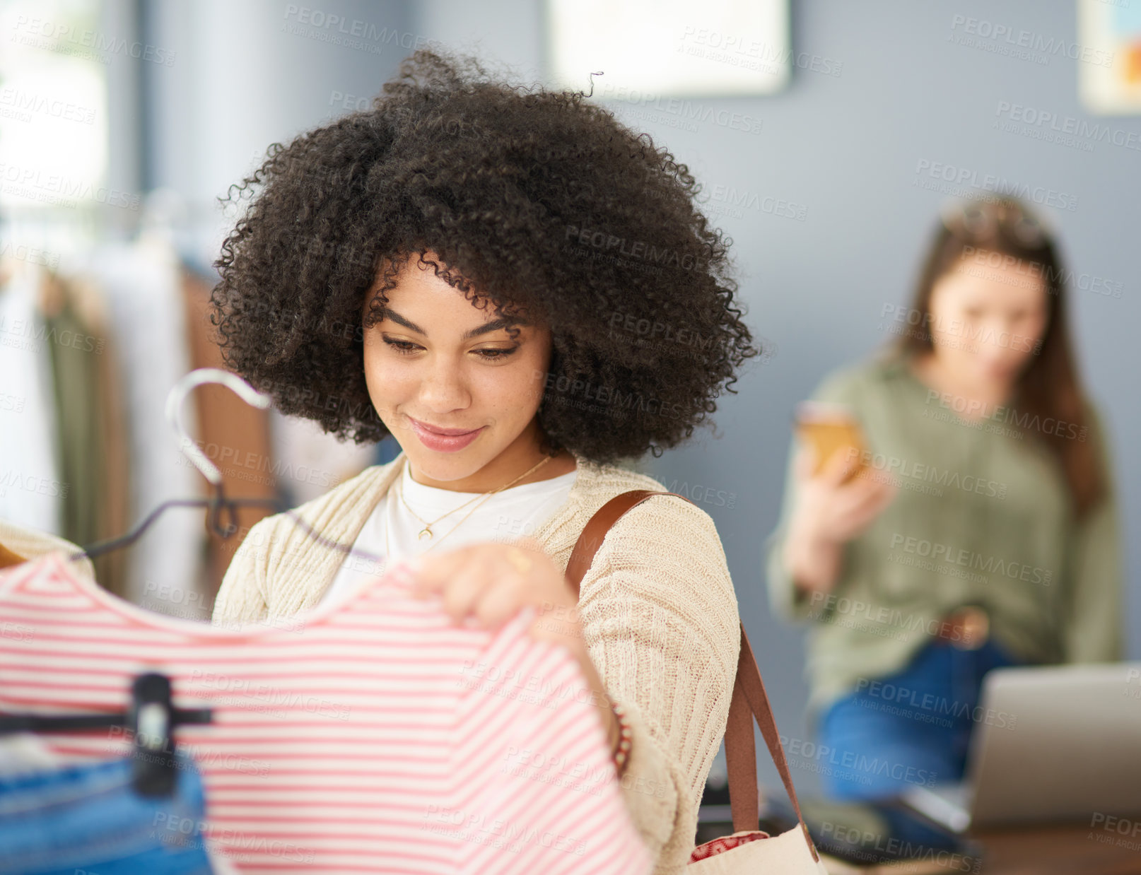 Buy stock photo Cropped shot of a young woman shopping for clothes in a store