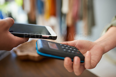 Buy stock photo Shot of a customer using her cellphone to do a payment in a store