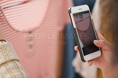 Buy stock photo Shot of a woman using her cellphone to take a picture of an item in a boutique
