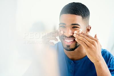 Buy stock photo Shot of smiling young man applying face cream