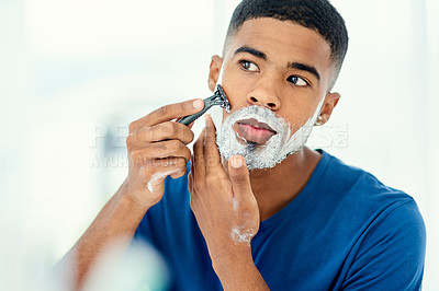 Buy stock photo Shot of handsome young man beginning to shave his face