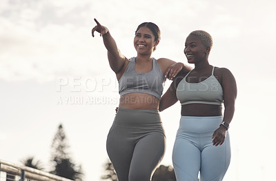 Buy stock photo Shot of two young women looking at something while out for a workout together