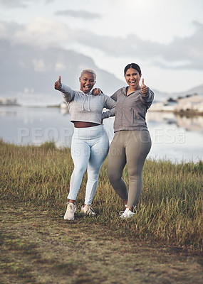 Buy stock photo Shot of two young women showing thumbs up while out for a workout