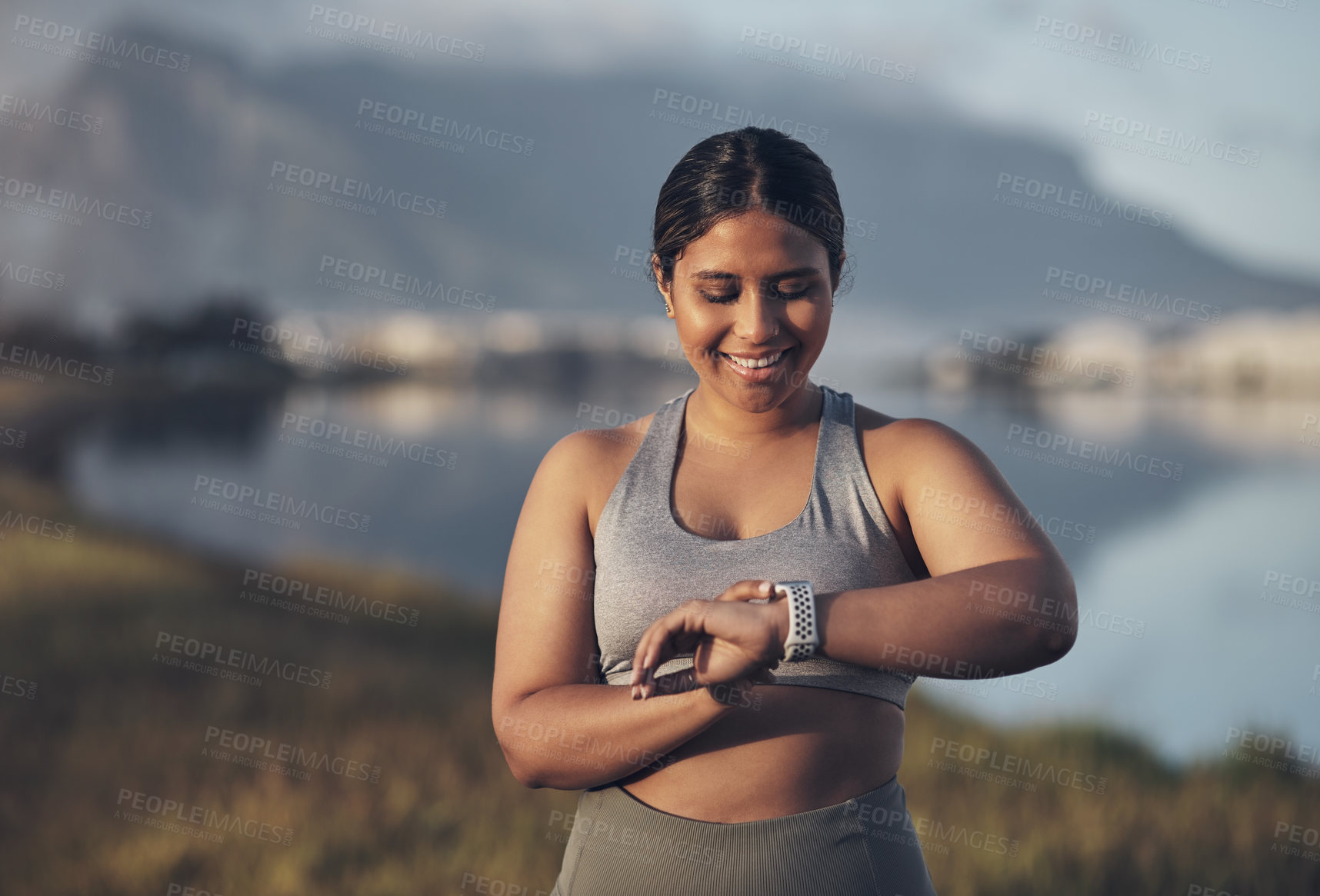 Buy stock photo Shot of a woman checking her smartwatch while out for a workout